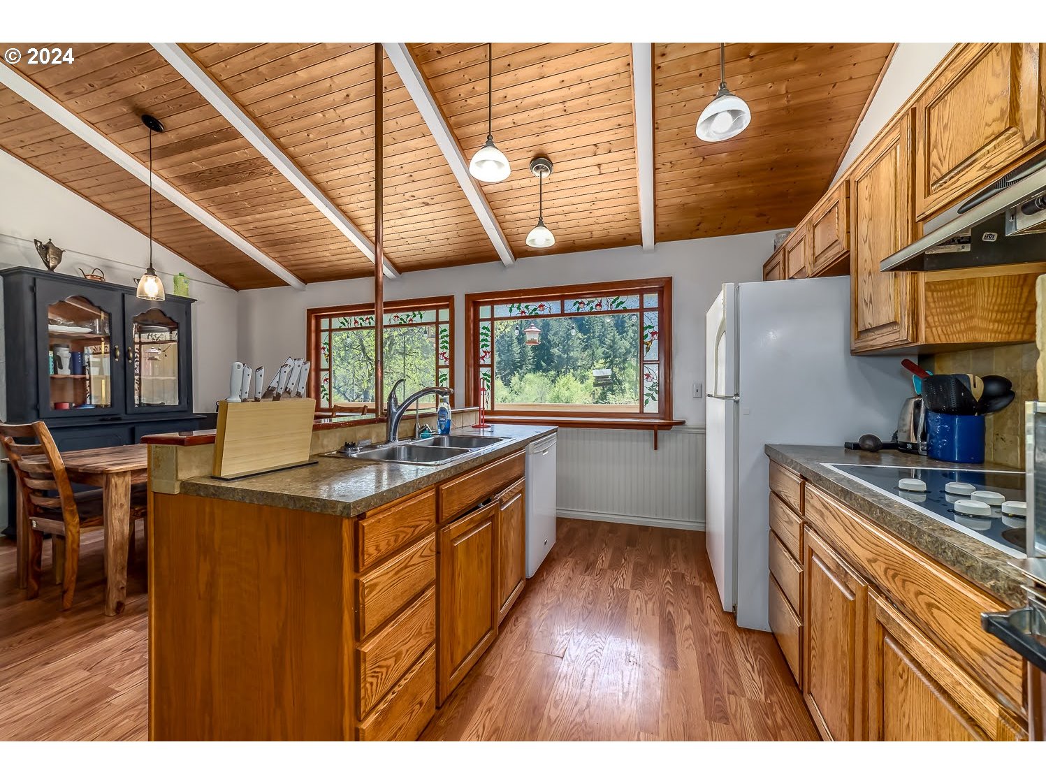 28149 Briggs Hill Road Eugene, OR 97405 - Photo 12 of 37 a kitchen with kitchen island granite countertop wooden cabinets a sink a stove and a refrigerator