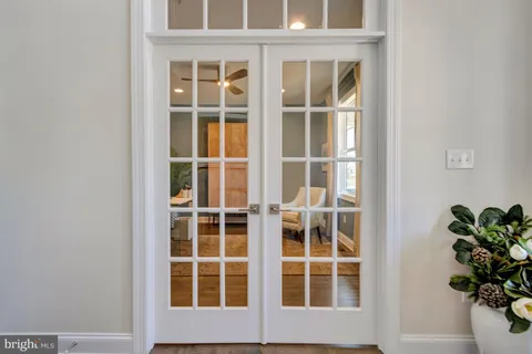 a view of a hallway with wooden floor and a bathroom