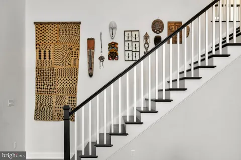 a bathroom with a granite countertop double vanity sink a toilet a mirror and shower