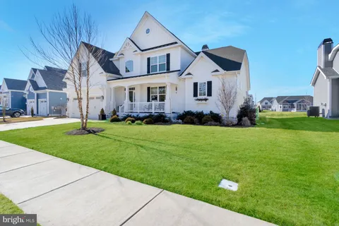 a view of a hallway with wooden floor and furniture