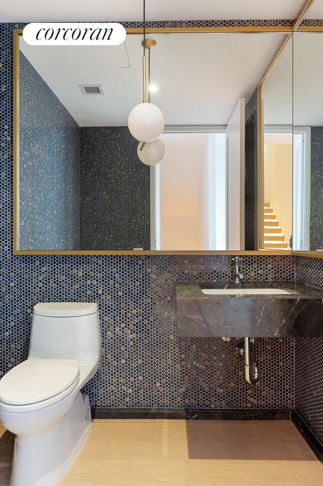 438 East 12th Street, Unit PHH Manhattan, NY 10009 - Photo 7 of 13 a bathroom with a sink a toilet and a mirror