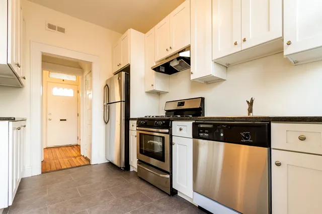 a kitchen with stainless steel appliances granite countertop a stove a refrigerator and a sink with cabinets