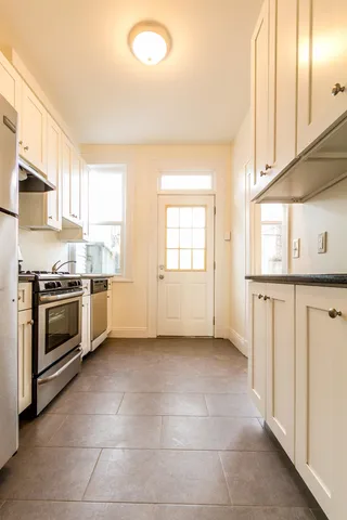 a kitchen with stainless steel appliances granite countertop a stove a sink and a refrigerator