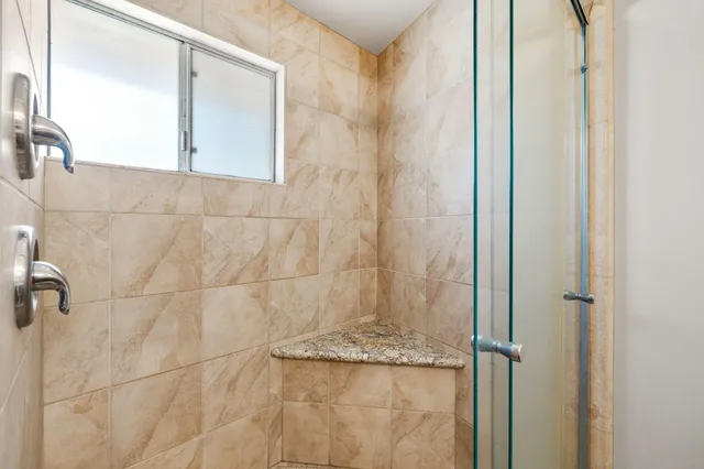 a bathroom with a granite countertop shower and a sink