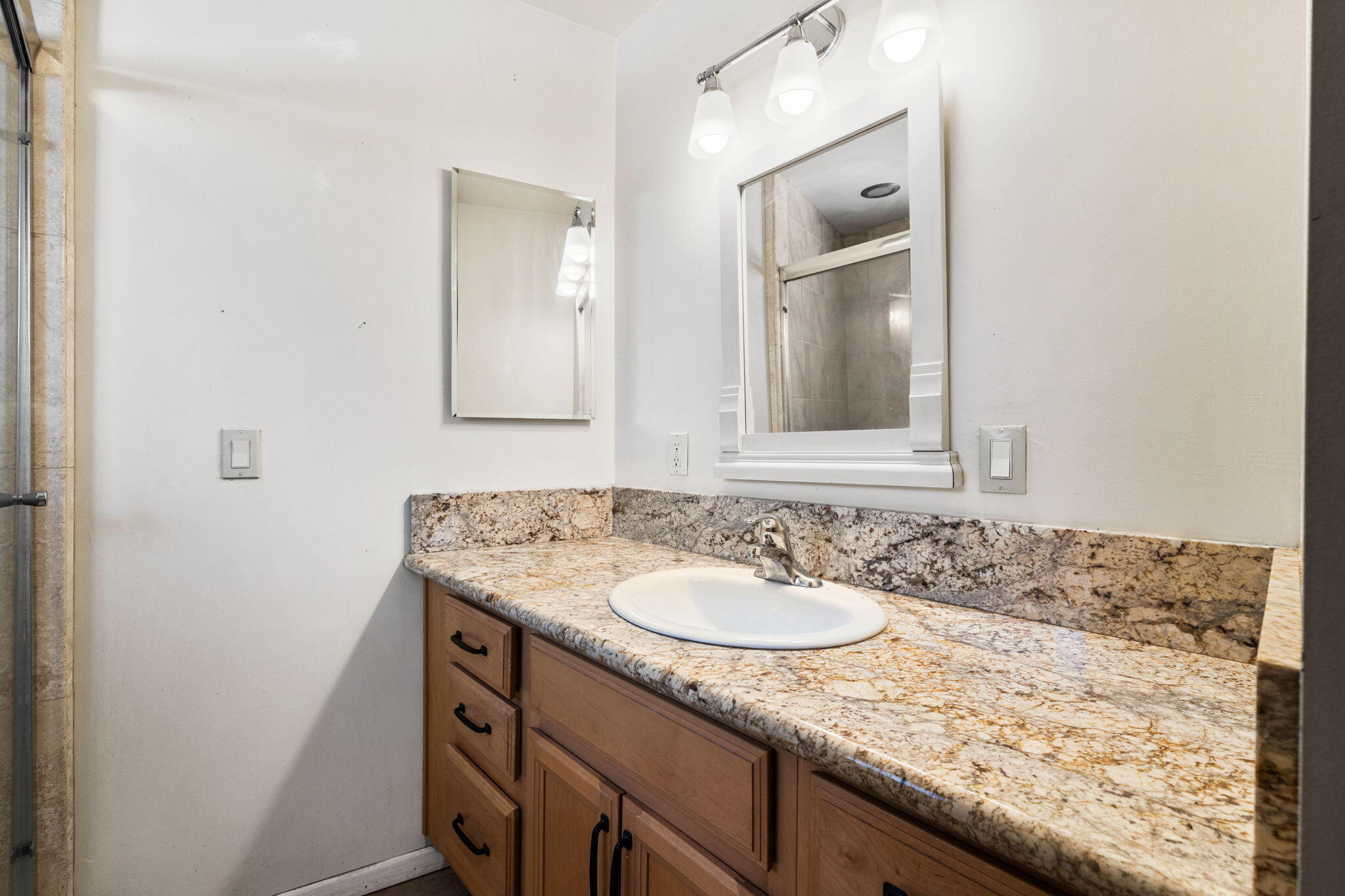 44510 San Carlos Avenue, Unit 4 Palm Desert, CA 92260 - Photo 10 of 12 a bathroom with a granite countertop sink and a mirror