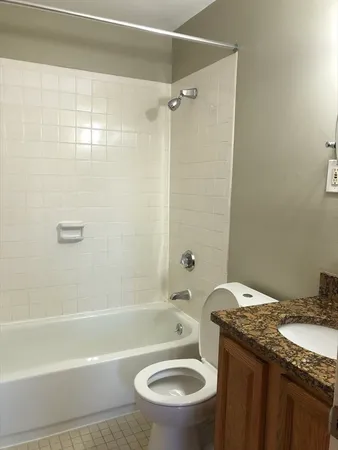 a bathroom with a granite countertop toilet sink and shower