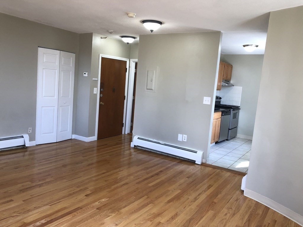 150 St Botolph Street, Unit 32 Boston, MA 02115 - Photo 5 of 8 an empty room with wooden floor and cabinet