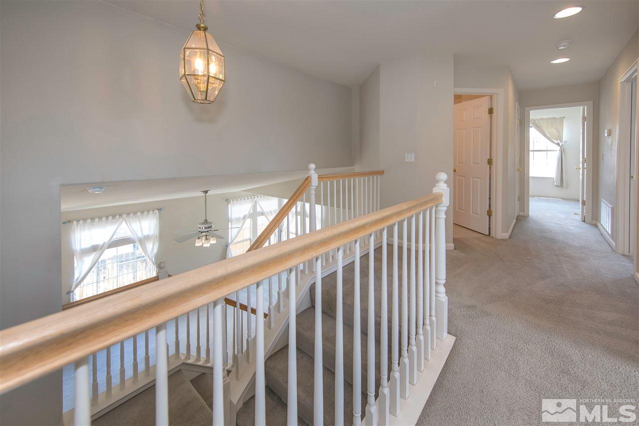 9910 Rock River Drive Reno, NV 89506 - Photo 18 of 24 a view of staircase with railing and a chandelier