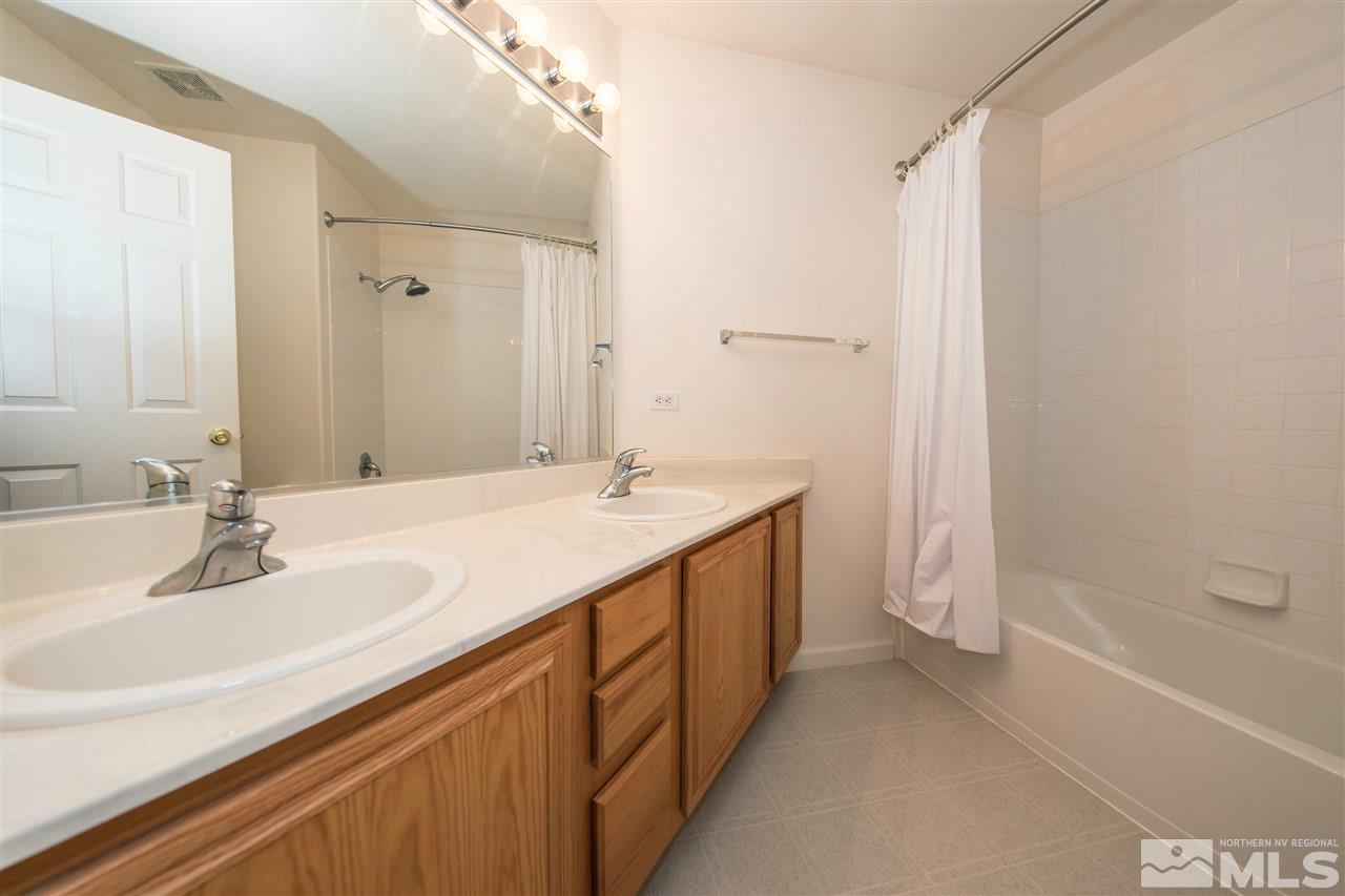 9910 Rock River Drive Reno, NV 89506 - Photo 19 of 24 a bathroom with a double vanity sink and a mirror