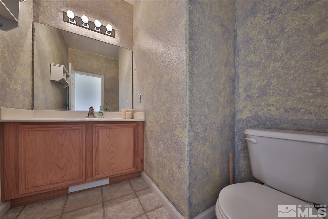 9910 Rock River Drive Reno, NV 89506 - Photo 21 of 24 a bathroom with a toilet a sink a mirror and vanity