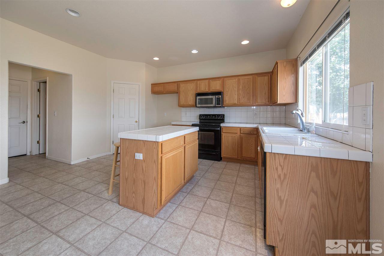9910 Rock River Drive Reno, NV 89506 - Photo 8 of 24 a large kitchen with stainless steel appliances granite countertop a stove a sink and a refrigerator