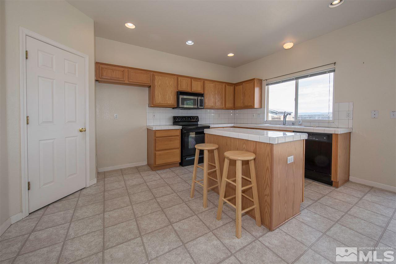 9910 Rock River Drive Reno, NV 89506 - Photo 10 of 24 a kitchen with stainless steel appliances granite countertop a stove top oven a sink a counter top space and cabinets