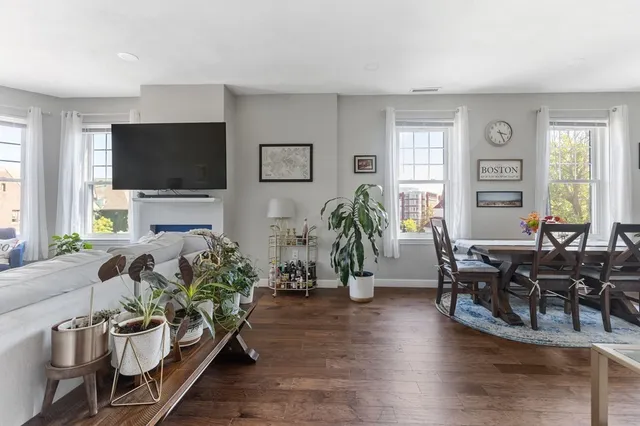 a living room with furniture flat screen tv and wooden floor