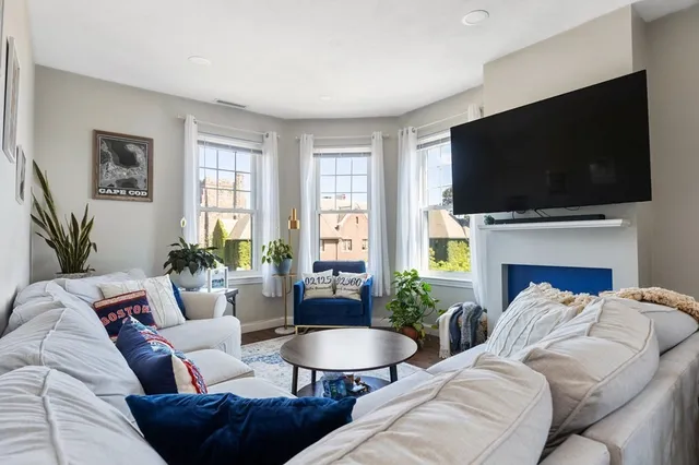 a living room with furniture a flat screen tv and a window