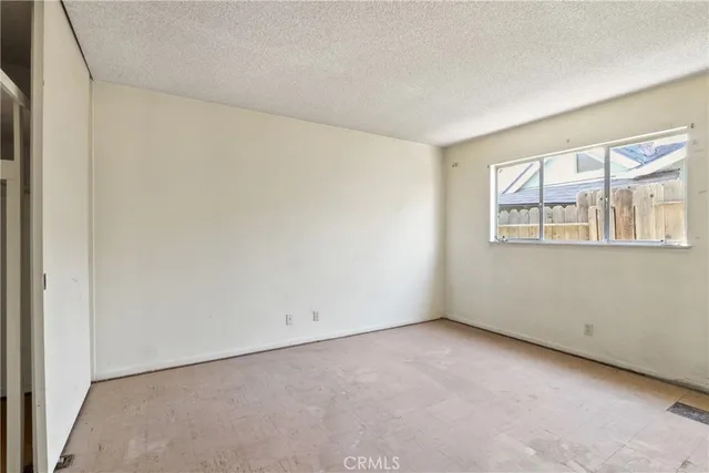 an empty room with closet and windows
