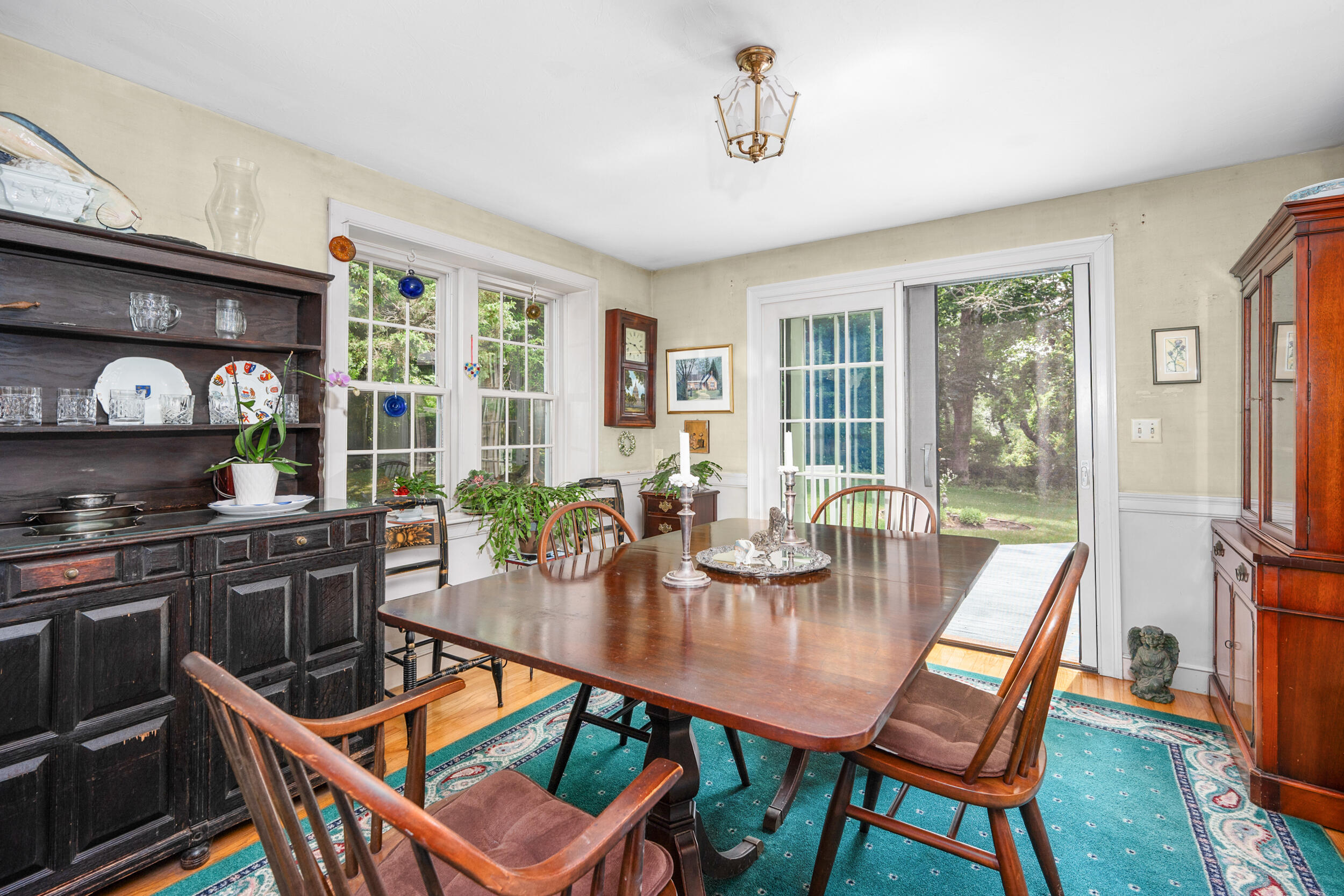 4323 Main Street Barnstable, MA 02630 - Photo 16 of 33 a dining room with wooden floor a glass table and chairs