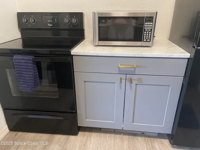 a kitchen with a stove and a wooden floor
