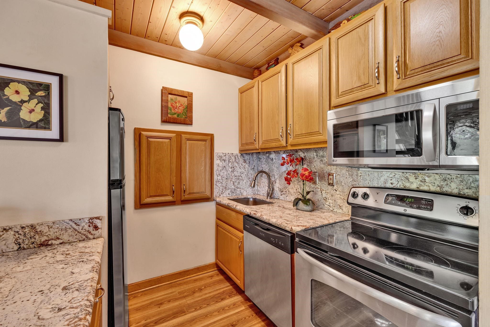 3691 Lower Honoapiilani Road, Unit 211 Lahaina, HI 96761 - Photo 11 of 47 a kitchen with stainless steel appliances granite countertop a stove and a microwave