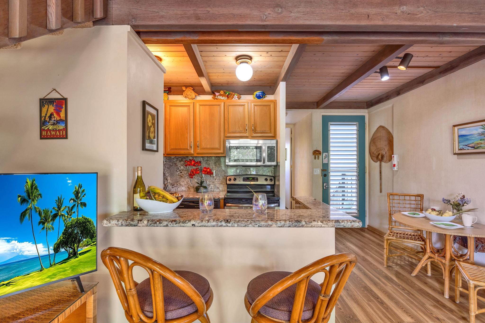 3691 Lower Honoapiilani Road, Unit 211 Lahaina, HI 96761 - Photo 37 of 47 a view of a dining room with furniture one side kitchen view and wooden floor