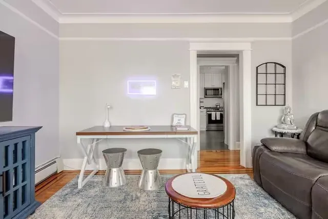 a living room with furniture a rug and a bookshelf