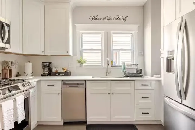 a kitchen with white cabinets and white appliances
