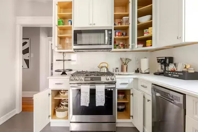 a kitchen with stainless steel appliances granite countertop a stove and a white cabinets