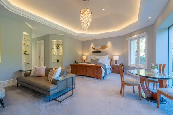 a spacious bedroom with a bed and a chandelier