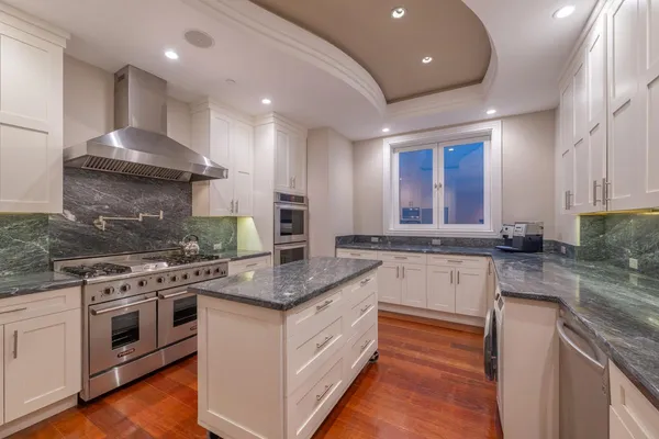a kitchen with stainless steel appliances granite countertop a stove a sink and a granite counter tops