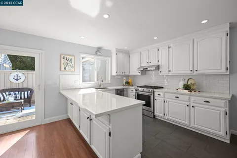 a kitchen with stainless steel appliances sink stove and cabinets