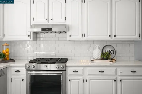 a kitchen with white cabinets and appliances