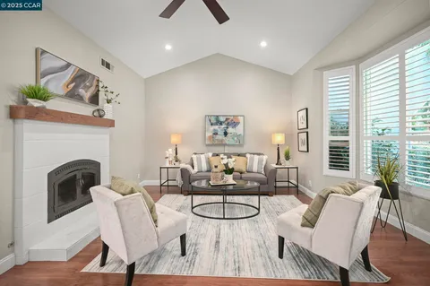 a living room with furniture a fireplace and a large window