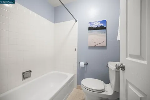 a white toilet sitting next to a bath tub