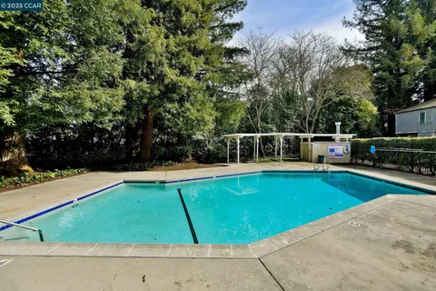 an aerial view of residential house with outdoor space and trees all around
