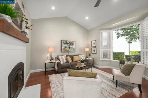 a living room with furniture a large window and a fireplace