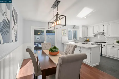 a open dining room with stainless steel appliances kitchen island granite countertop furniture and a kitchen view
