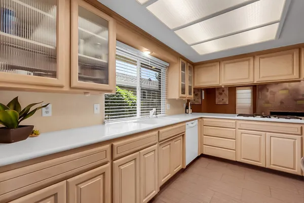 a kitchen with white cabinets and window