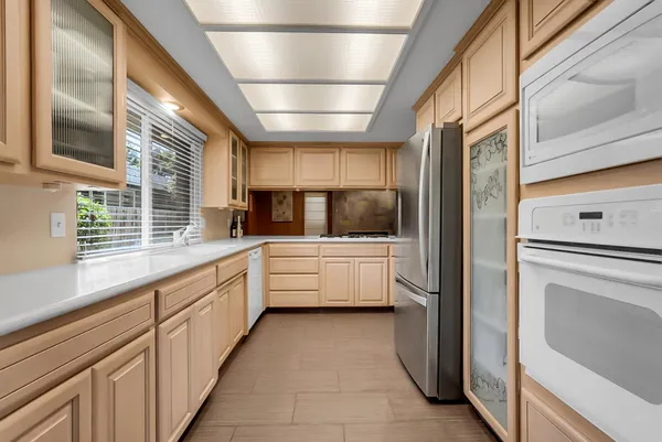 a large white kitchen with a large window