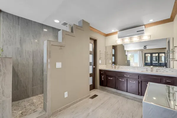 a spacious bathroom with a granite countertop sink mirror and shower