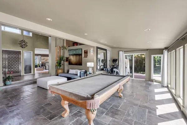 a living room with furniture a flat screen tv and a dining table