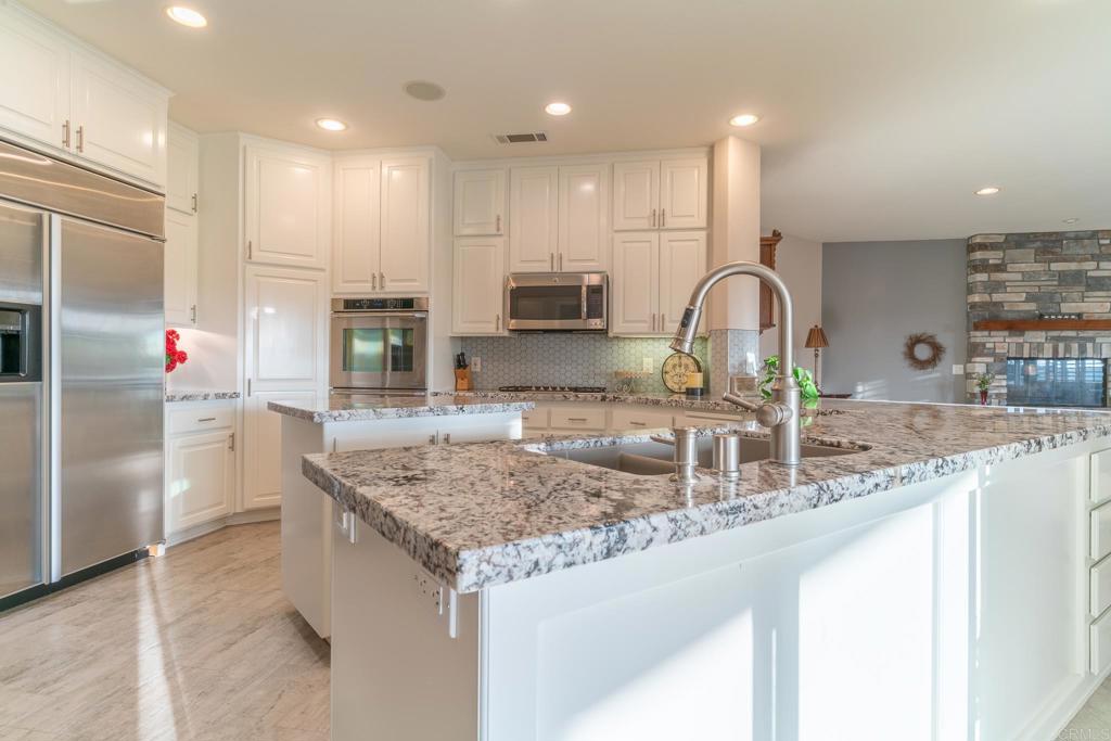 30646 Red Hawk Road Valley Center, CA 92082 - Photo 14 of 69 a kitchen with kitchen island granite countertop a sink and refrigerator