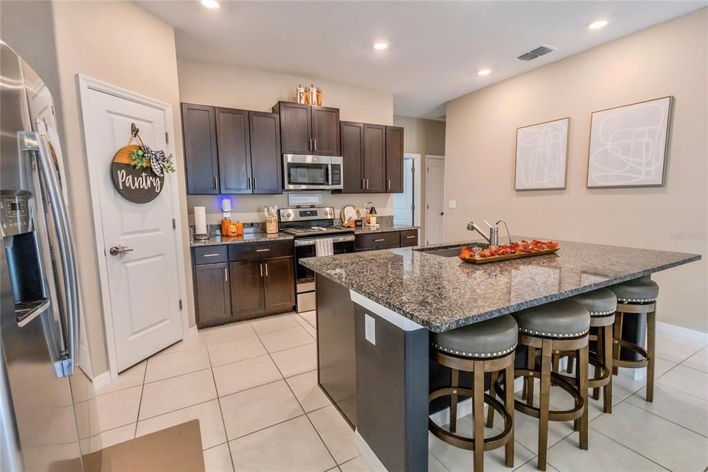 1628 Red Loop Lakeland, FL 33801 - Photo 11 of 37 a kitchen with stainless steel appliances granite countertop a stove a sink and a refrigerator