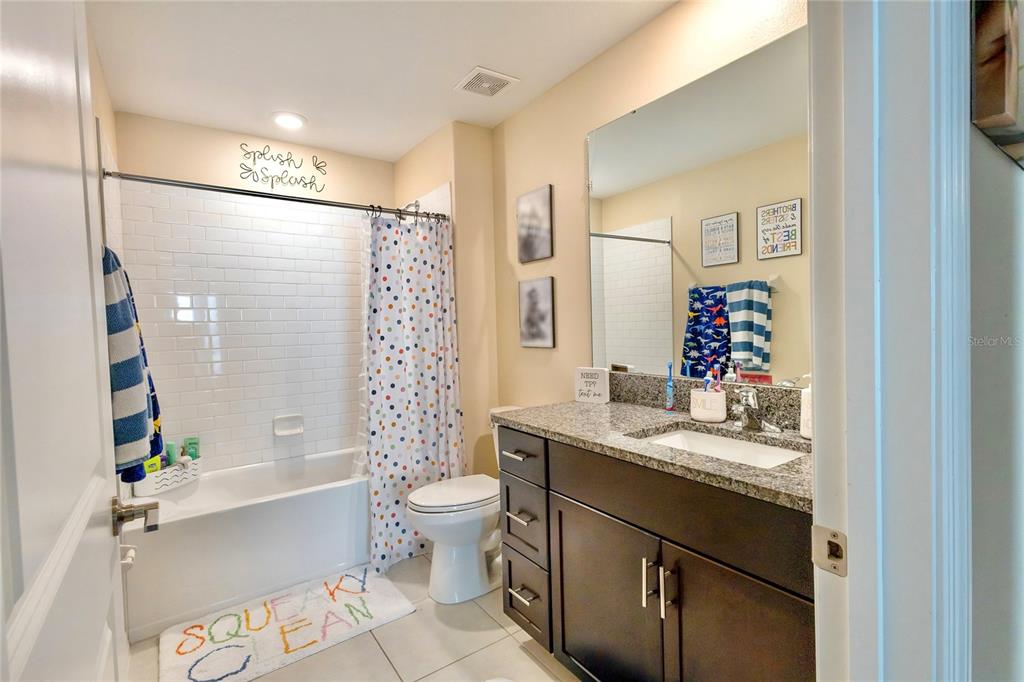1628 Red Loop Lakeland, FL 33801 - Photo 24 of 37 a bathroom with a granite countertop sink toilet mirror and bathtub
