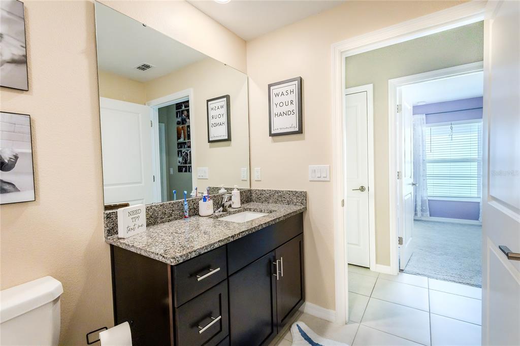 1628 Red Loop Lakeland, FL 33801 - Photo 25 of 37 a bathroom with a granite countertop sink and a mirror