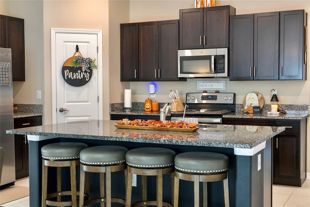 1628 Red Loop Lakeland, FL 33801 - Photo 10 of 37 a kitchen with granite countertop a table chairs stove and microwave
