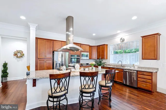 a kitchen with stainless steel appliances a dining table and chairs
