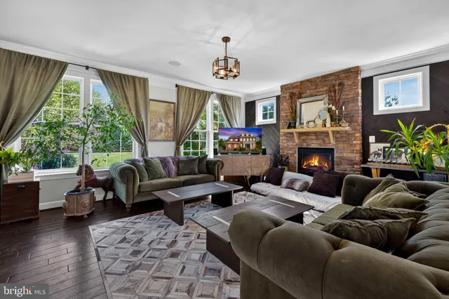 a living room with furniture a large window and a fireplace