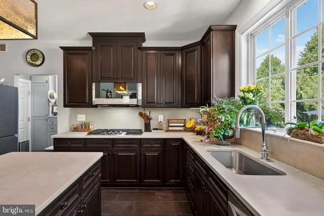 a kitchen with a sink a stove cabinets and a window