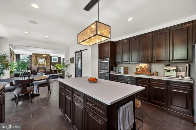 a kitchen with kitchen island granite countertop a sink a counter space and stainless steel appliances