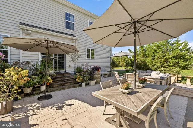 a view of a patio with table and chairs under an umbrella