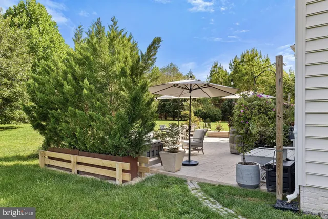 an outdoor sitting area with chairs and wooden fence